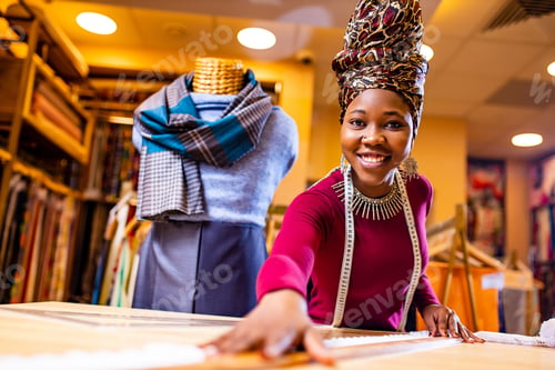 Preview: tanzanian woman with snake print turban over hear working in fabrics shop