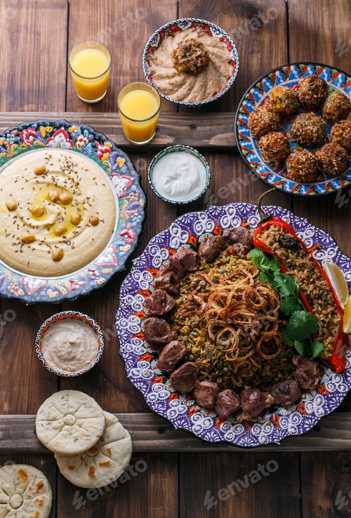 Preview: Middle eastern or arabic pilaf with hummus, falafel, eggplant dip and pitas top view