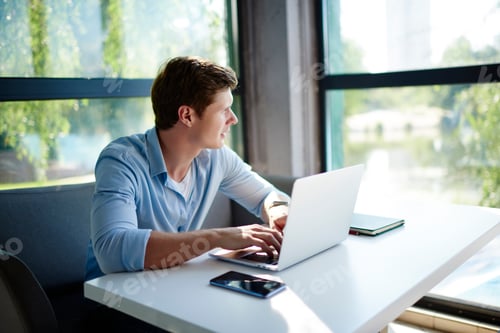 Preview: Pensive male programmer with laptop computer spending daytime for doing distance job