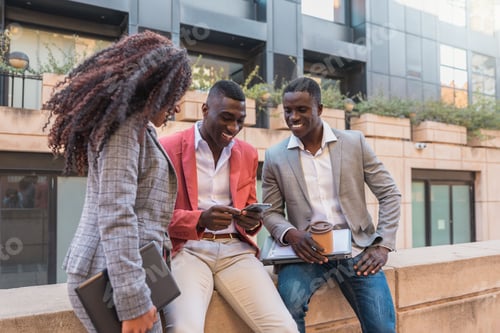 Preview: Group of Smiling multiracial Business people using smartphone during coffee break outdoors