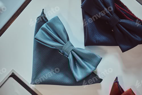 Preview: Close-up photo of a silk bow ties different colors on table in a menswear store.