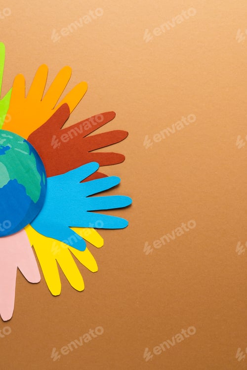 Preview: Paper cut out of multi coloured hands and globe with copy space on brown background