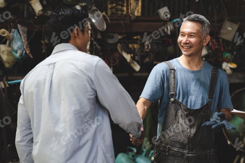 Preview: Mechanic technician man shaking hands with customer after finish checking the car at garage