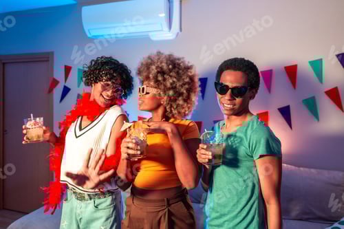 Preview: Multiracial friends drinking and dancing at home at night