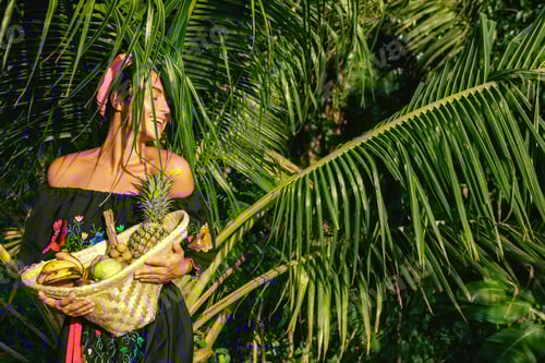 Preview: Happy young woman with a basket full of exotic fruits