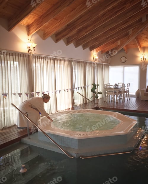 Preview: Woman testing water temperature at luxury spa day