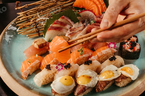 Preview: Person holding a sushi with chopsticks