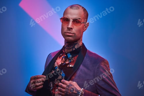 Preview: Fashionable tattooed male model posing in a studio