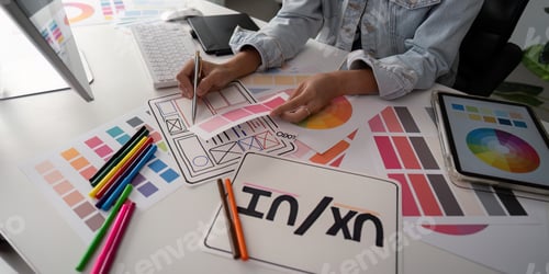 Preview: Stylish woman Ux designer using digital tablet and computer planning new website wireframe at