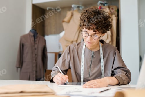 Preview: Young female designer concentrating on looking though digital models