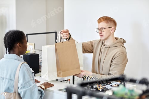 Preview: Store manager handing paper bags
