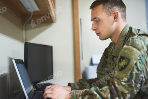 Preview: Shot of a young soldier using a laptop in the dorms of a military academy