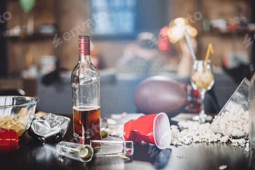 Preview: Close-up view of popcorn, glasses and trash on messy table after party