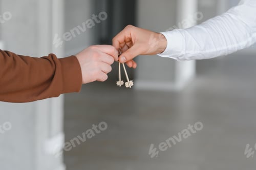 Preview: Real estate agent holding key and house model