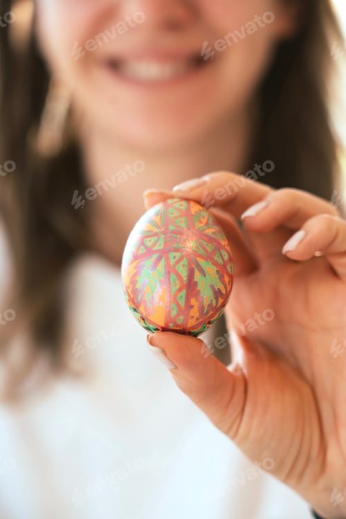 Preview: Young woman holding painted Easter egg