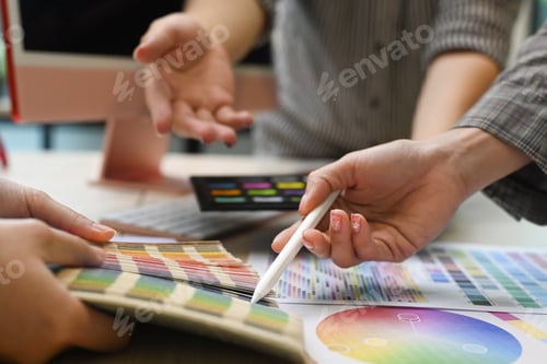 Preview: Close up view team of graphic designers working with color swatches and brainstorming.