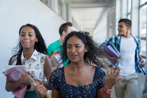 Preview: Students with books chatting in a school hallway