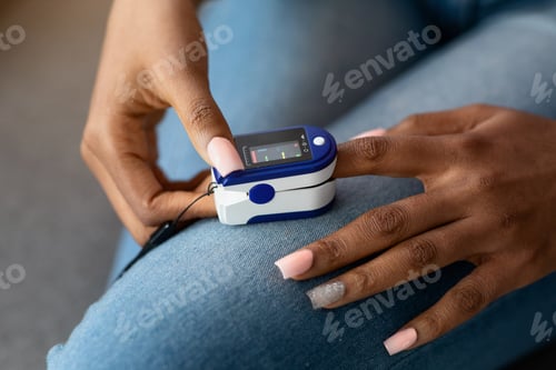 Preview: Unrecognizable African American Woman Using Oximeter At Home, Checking Oxygen Saturation