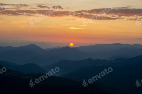 Preview: Mountain range under bright orange sunset skies