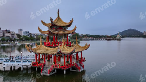 Preview: Traditional pavilion on a lake in Kaohsiung, Taiwan at dusk surrounded by cityscape
