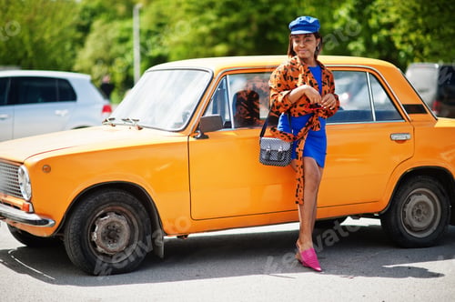 Preview: African american lady near orange classic retro car