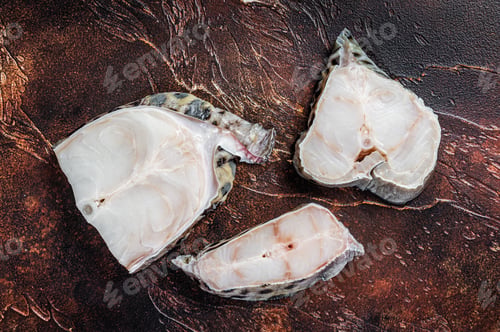 Preview: Raw atlantic wolffish fish Steak. Dark background. Top view