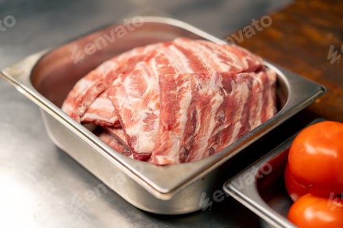 Preview: close-up in professional kitchen in a rib cage there are ribs for cooking on an iron table