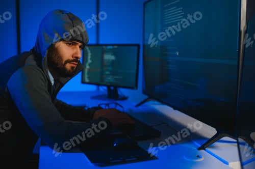 Preview: Hacker with computer, man sitting at a table in a hoody