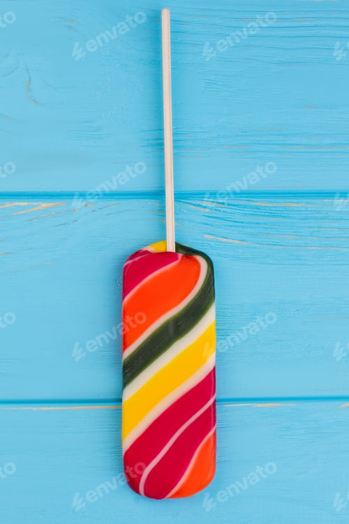 Preview: Multicolored lollipop on blue background.