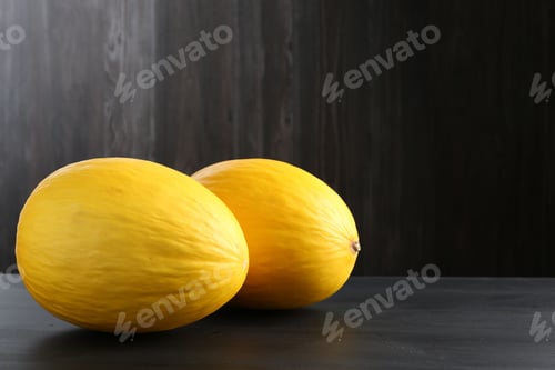 Preview: Whole ripe melons on black wooden table. Space for text