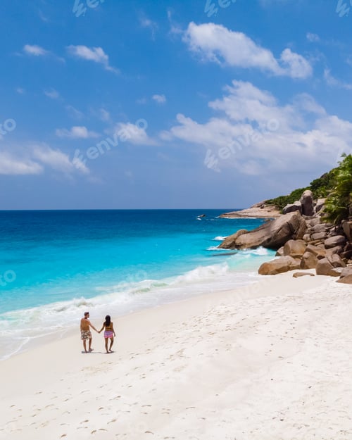 Preview: Young couple men and woman at a tropical beach in the Seychelles Cocos Island, drone view