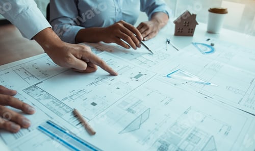 Preview: Architects engineer working with blueprints on table and discussing project together