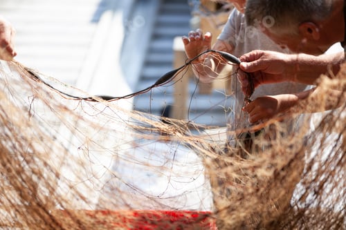 Preview: Fisherman and boy disentangling fishing net