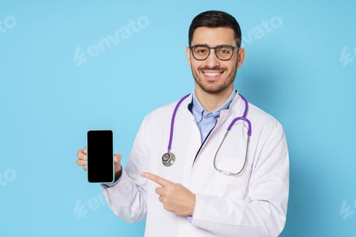 Preview: Portrait of young handsome doctor presenting smart phone with blank screen