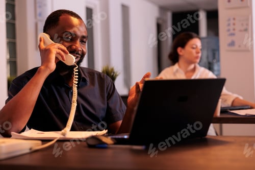 Preview: Corporate worker discussing project plan on landline phone