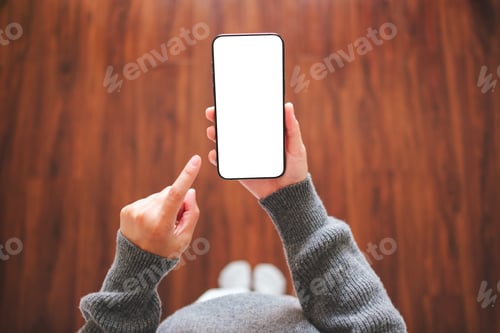 Preview: A woman holding and pointing at mobile phone with blank desktop white screen