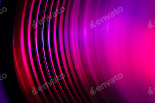 Preview: Closeup of coiled metal spring rings in a compressed state in red neon light