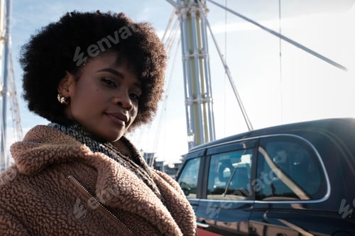 Preview: Young woman looking at camera standing on bridge.