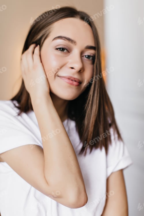 Vista previa: Hermosa jovencita de cabello oscuro posando con una sonrisa interesada. Foto interior de increíble modelo femenina