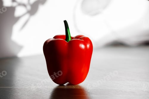 Preview: fresh red pepper on a table with sun light from kitchen window