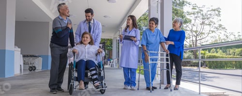 Preview: Doctors and nurse in hospital corridor with senior female and senior male patient in walker