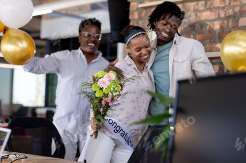 Preview: Congratulating coworker with flowers, African American colleagues celebrating success in office