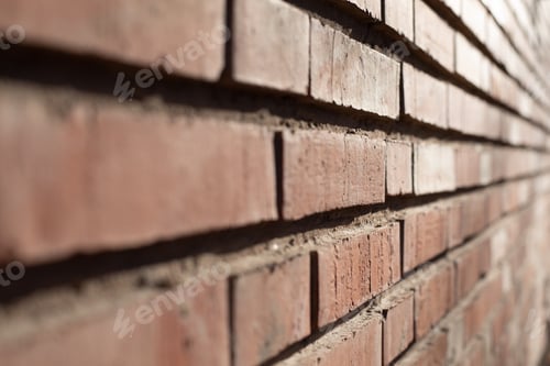 Preview: Red brick wall with side light at sunset, textured background and space for masonry text.