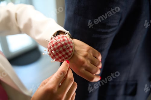 Preview: Master tailor adjusting customer clothing during fitting session