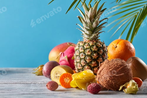 Preview: Creative exotic composition with tropical fruits and green leaves pineapple, coconut, mango, kiwi