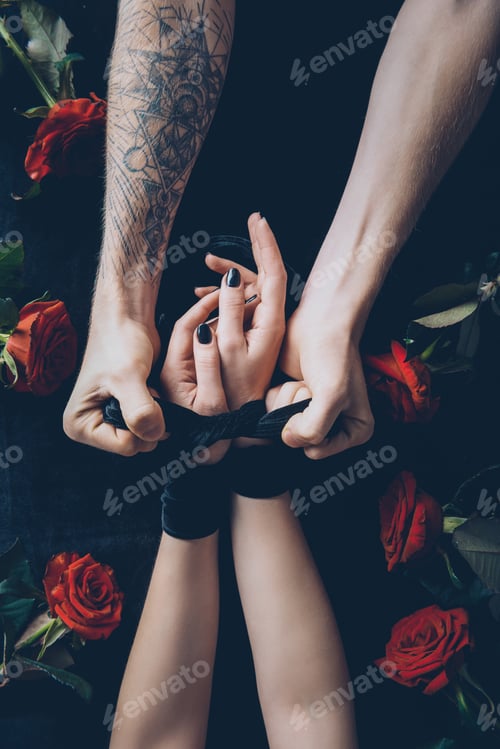 Preview: partial view of man tying female hands with black ribbon