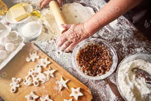 Preview: Skilled cook rolling out cookie dough in kitchen