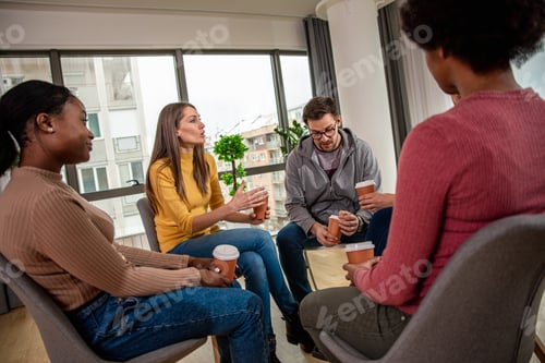 Preview: Diverse group of people sitting in circle in group therapy session.