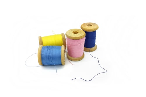 Preview: Spools of multi-colored threads on a white background