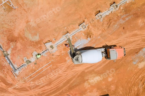 Preview: Aerial view of construction site where concrete mixer truck is pouring fresh concrete into forms